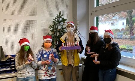 Auf dem Bild sieht man fünf Schülerinnen und Schüler der SMV mit Nikolausmützen und Schokonikoläusen.
