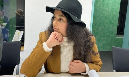 Ein Mädchen mit Hut und Mantel verkleidet