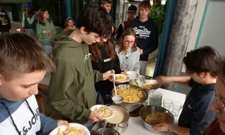 Jugendliche schöpfen sich Nudeln mit Soße