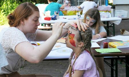 Eine Lehrerin schminkt ein Mädchen