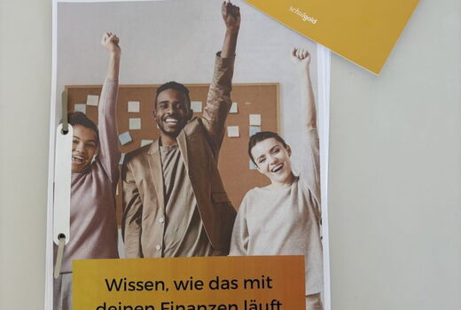 Ein Plakat auf dem drei junge Menschen den linken Arm im Triumph hochheben und lachen. Hier steht: Wissen, wie das mit deinen Finanzen läuft #GeldcheckerIn