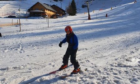 Ein Kind fährt Ski auf einem sonnigen Hang