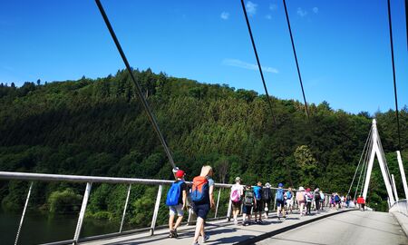 Lehrerin überquert mit den Schülerinnen und Schülern in Zweierreihen eine große Brücke