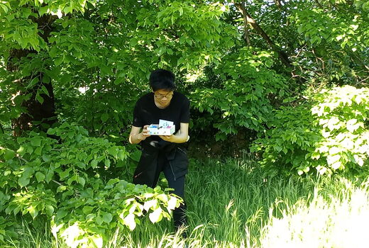 Ein Schüler hat erfolgreich sein Osternest im hohen Gras gefunden.