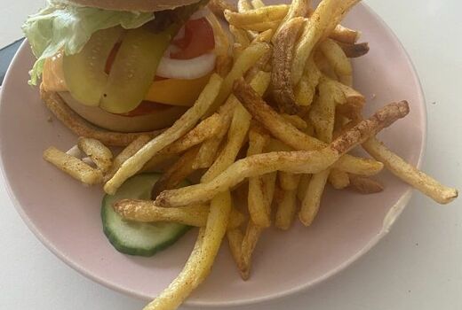 Ein Teller mit einem Hamburger und Pommes.