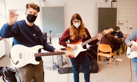 Fünf Schüler üben E-Gitarre