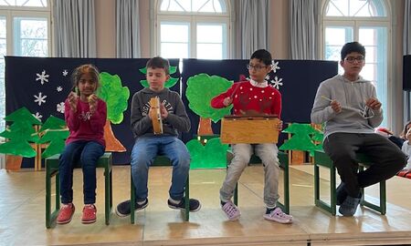 Vier Kinder vertonen die Geschichte "Es klopft bei Wanja in der Nacht". Sie haben Musikinstrumente in der Hand