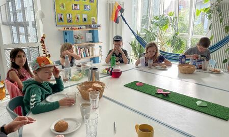 Kinder sitzen an einem Frühstückstisch