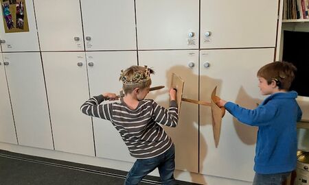 Jungen kämpfen mit Holzschwertern