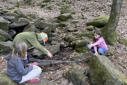 Kinder bauen eine Brücke am Bach