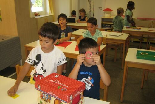 Zwei Jungen ziehen aus einem Fühlhaus den Buchstaben O.
