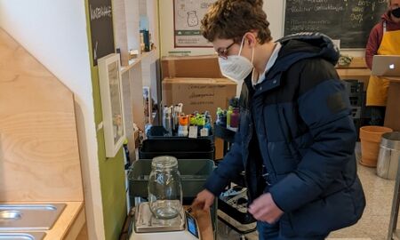 Ein Junge wiegt ein leeres Schraubglas