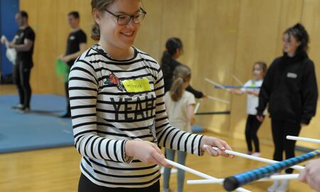 Mädchen balanciert mit Stäben