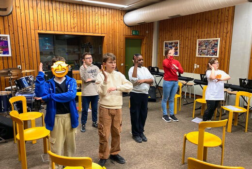 SchülerInnen formen mit ihren Armen ein Segelboot