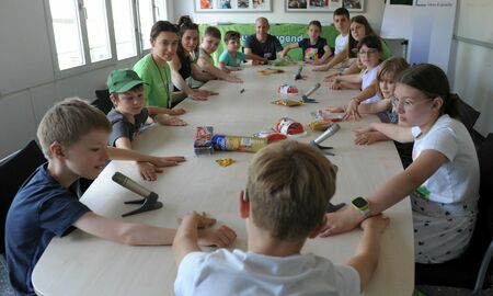 Die Kinder spielen am Tisch ein Klopfspiel mit ihren Händen