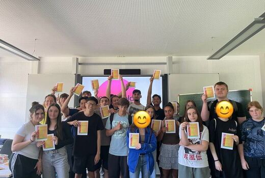 Viele SchülerInnen haben sich zum Gruppenfoto aufgestellt. Sie lachen und halten ihre Zertifikate in die Höhe.