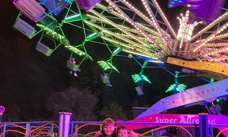 Zwei Schüler stehen vor einem Fahrgeschäft