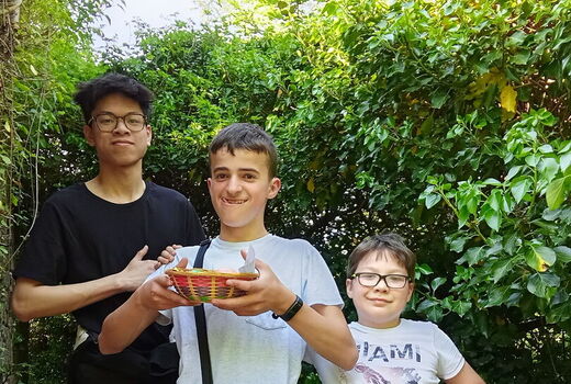 Drei Schüler präsentieren stolz ihren Osterkorb, den sie gefunden haben.
