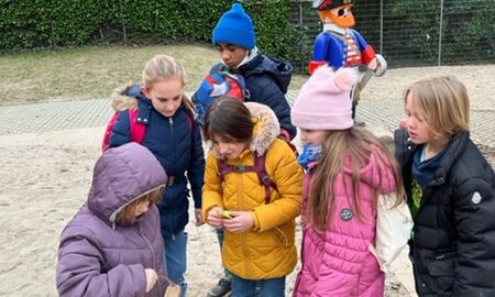 Sechs Kinder stehen in einem Sandkasten