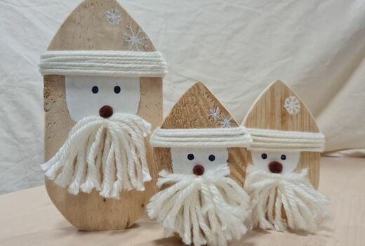 Drei Wichtel zum Aufstellen aus hellem, naturbelassenem Holz. Die Krempe der Mützen und die Bärte sind aus weißer Wolle.