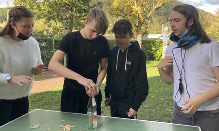 Schüler/innen stapeln Streichhölzer auf der Glasflasche