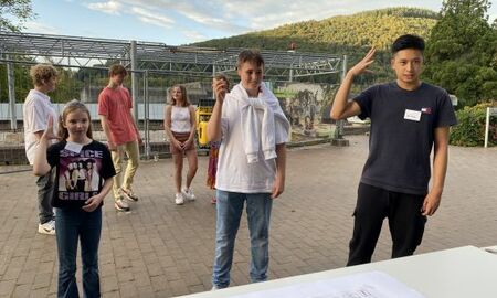 Zwei Jungen und ein Mädchen gebärden ein Gedicht