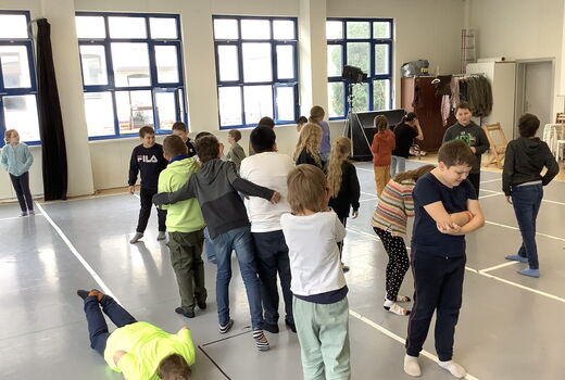 Einige Kinder stehen im Raum und stellen das Gefühl Kummer mimisch und gestisch dar
