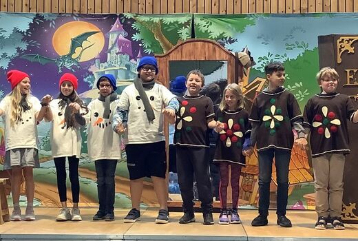 Acht Schüler und Schülerinnen mit der Schauspielerin und dem Schauspieler auf der Bühne