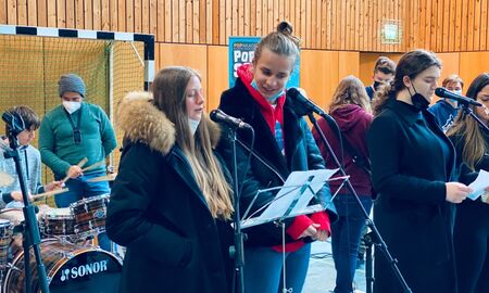 Schüler singen während im Hintergrund Schlagzeug gespielt wird