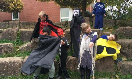 Verkleidete Kinder posieren gruselig auf einer Steintreppe.