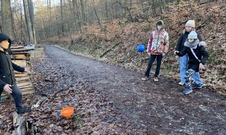 Vier Jugendliche spielen im Wald ein Ballspiel