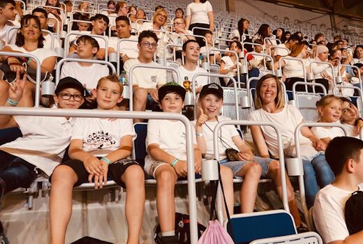 Schülerinnen und Lehrerinnen sitzen in der Pause auf der Tribüne