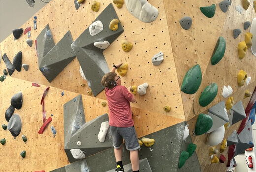 Ein Junge klettert eine Wand hoch.