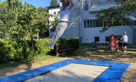 Ein Junge wird von einem Bodentrampolin in die Höhe geschleudert