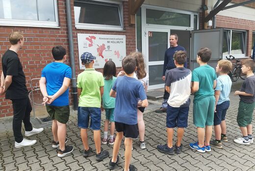 Kinder schauen sich mit einem Mitarbeiter eine Schautafel an