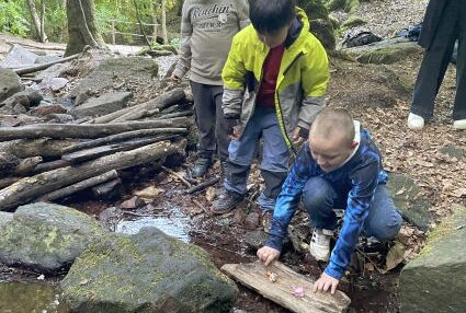 Kinder bauen ein Boot aus Rinde