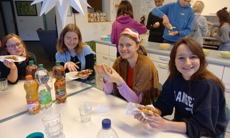 Vier junge Frauen essen Hot Dogs