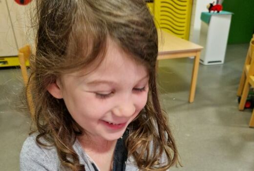 Auf den Händen eines Mädchens sitzt ein geschlüpfter Schmetterling.