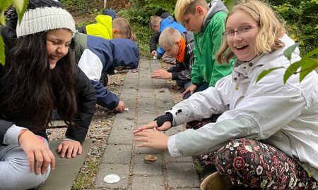 Schülerinnen und Schüler verbrennen Wattepads und halten zum Schutz ihre Hände darüber, damit sie besser verbrennen.