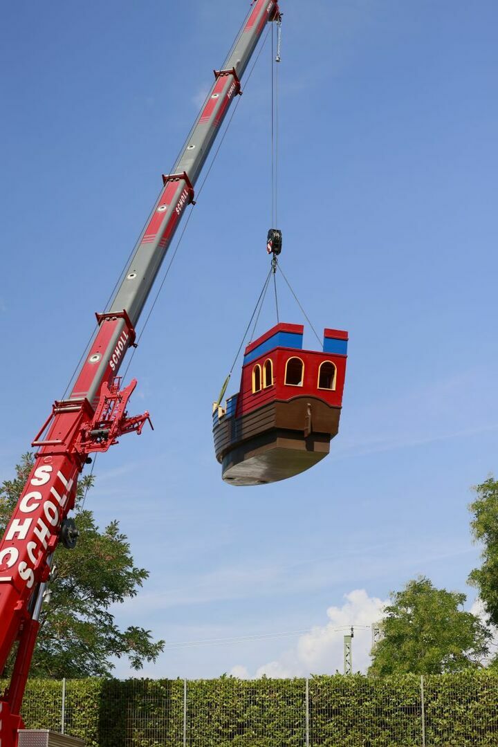 Das Playmobil-Schiff wird mit einem Kran über die Hecke gehoben (2).