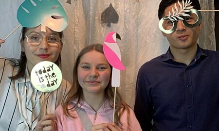 drei Jugendliche vor einer Fotowand