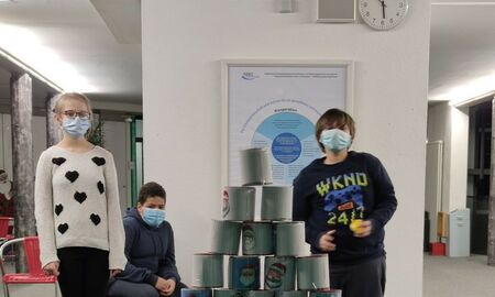 Drei SchülerInnen schauen auf den Dosenturm.