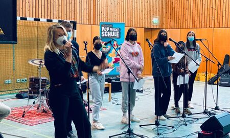 Gesangsprobe mit fünf Schülern und einem Mitglied der Popakademie in der Turnhalle