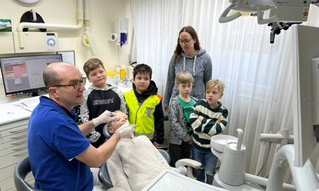 Kinder schauen bei der Behandlung eines Mitschülers zu