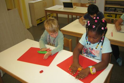 Ein Mädchen und ein Junge kneten.