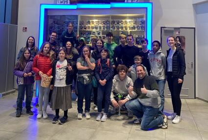 Eine Gruppe Jugendlicher mit Betreuern machen ein Gruppenfoto in einem Kino