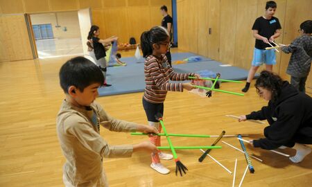 Zirkuskinder balancieren mit Stäben
