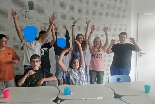 Neun SchülerInnen strecken als Zeichen ihrer Freude die Hände in die Höhe.
