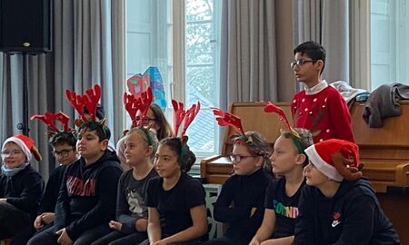 acht Kinder tragen Rentiergeweihmützen