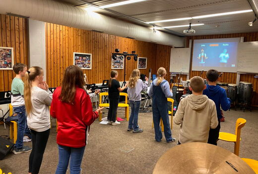 SchülerInnen schauen auf ein Board und tanzen